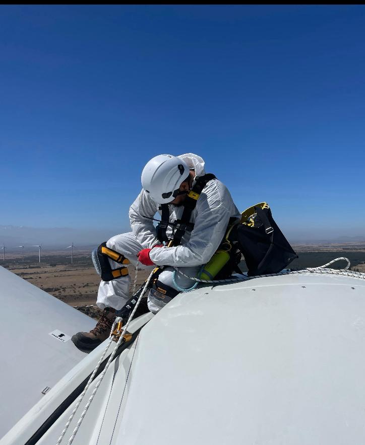 Técnico executando serviço sobre a nacele de um aerogerador