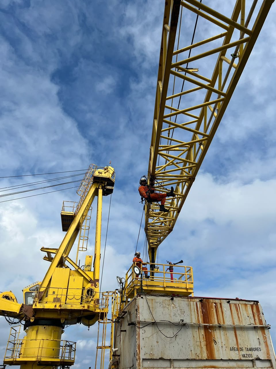 Técnicos em acesso por cordas na lança de um guindaste offshore